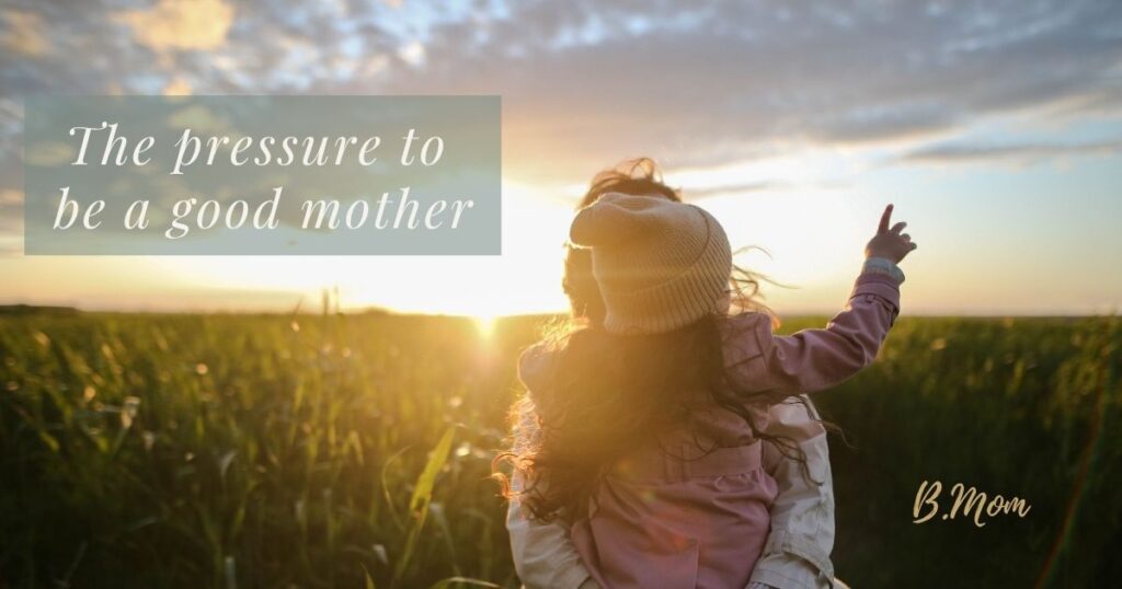 A mother holding a child in a sunlit field, with text reading: “The pressure to be a good mother.”